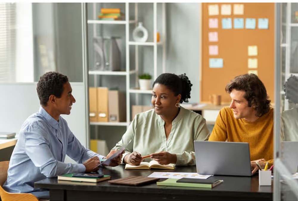 A recruitment team reviewing candidates together around a desk